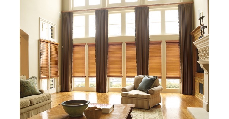 Charlotte great room with natural wood blinds and full-length drapes.